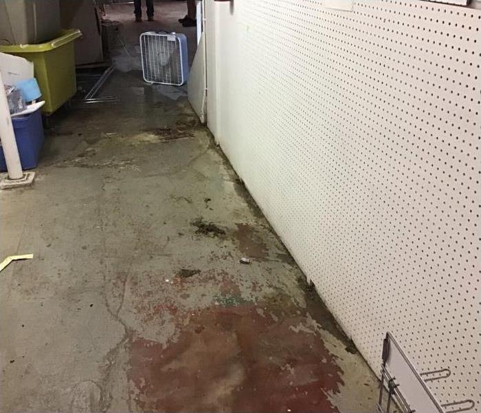 Pegboard wall and dirty cement flooring.