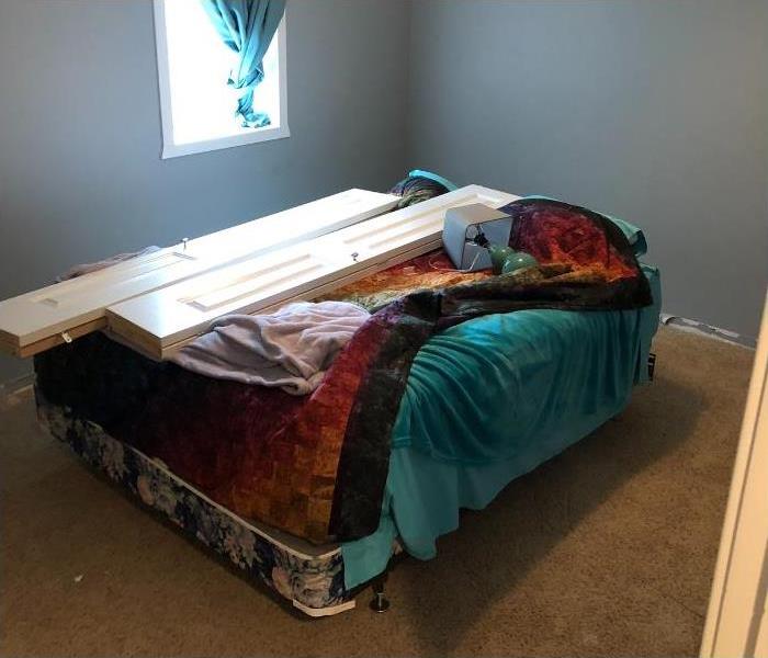 A bedroom with no trimming and a bed in the middle of the room.