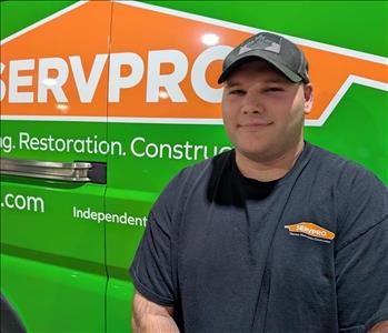 smiling man in front of green truck